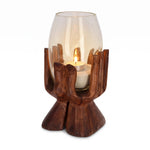 Teelichthalter Holz 30 cm: handgeschnitzte Holzhand aus Suarholz hält ein hohes Glas mit hellem Sand und brennendem Teelicht, freigestellt vor Weiß.