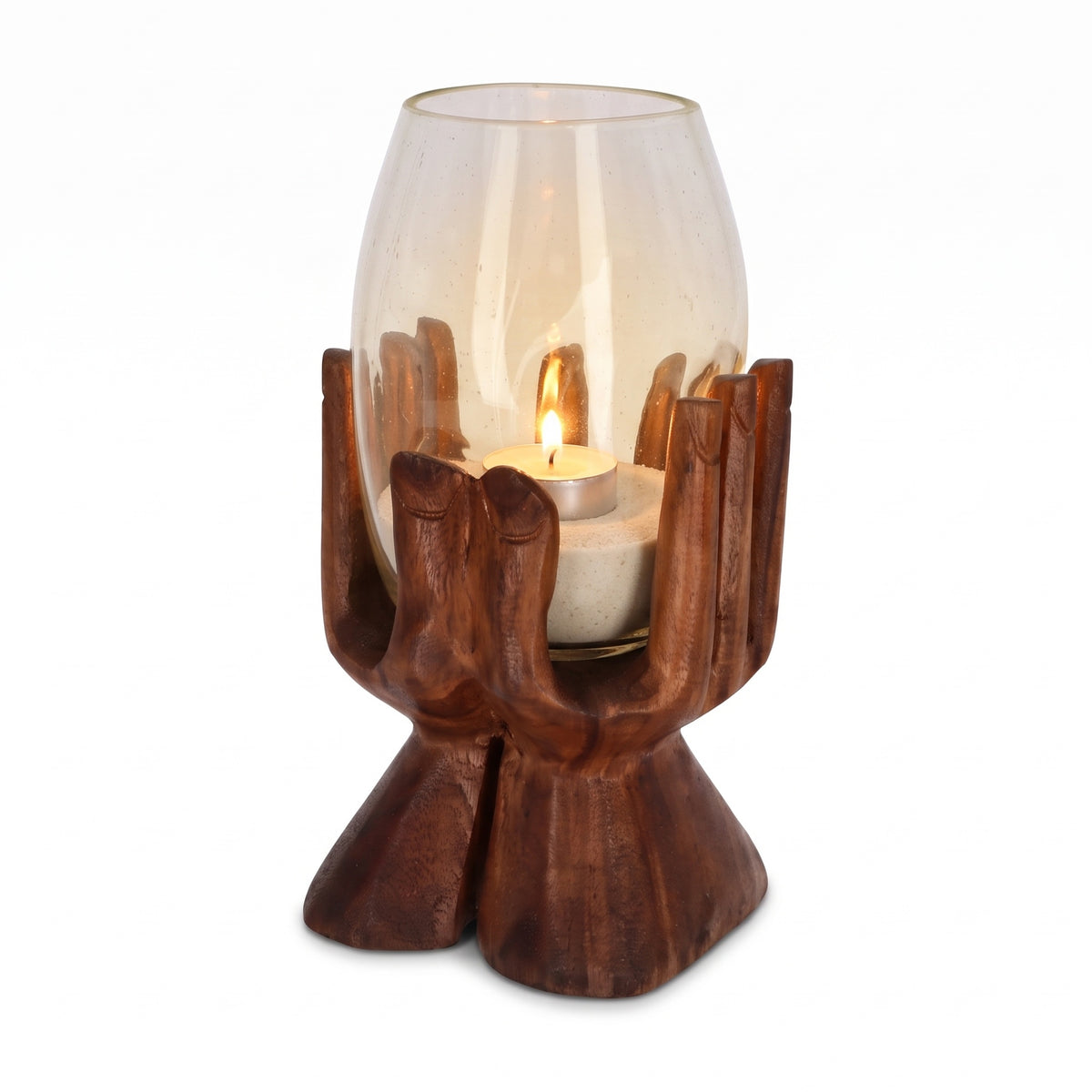 Teelichthalter Holz 30 cm: handgeschnitzte Holzhand aus Suarholz hält ein hohes Glas mit hellem Sand und brennendem Teelicht, freigestellt vor Weiß.
