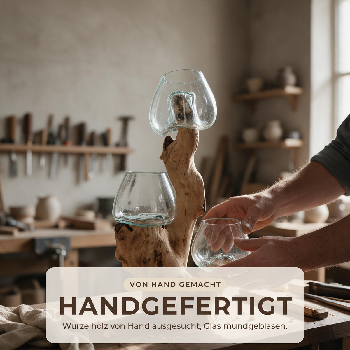Hände setzen in einer Werkstatt ein mundgeblasenes Glas in die Wurzelholz-Skulptur ein