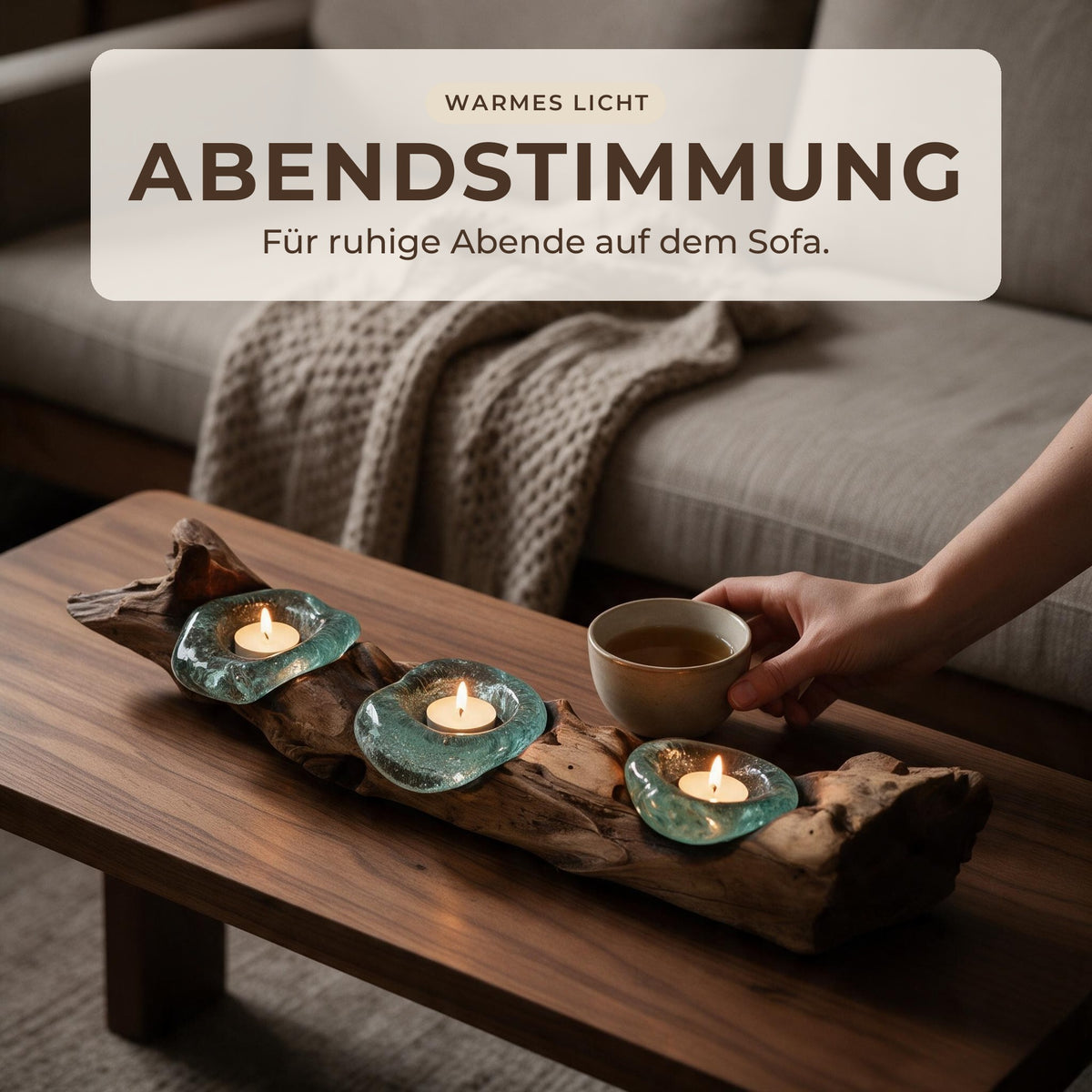 Abendstimmung: Hand stellt Tee neben den Teelichthalter mit drei brennenden Teelichtern auf dem Couchtisch